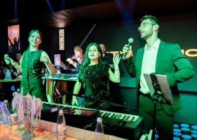 Бендът пее и танцува пред надписа Let's dance